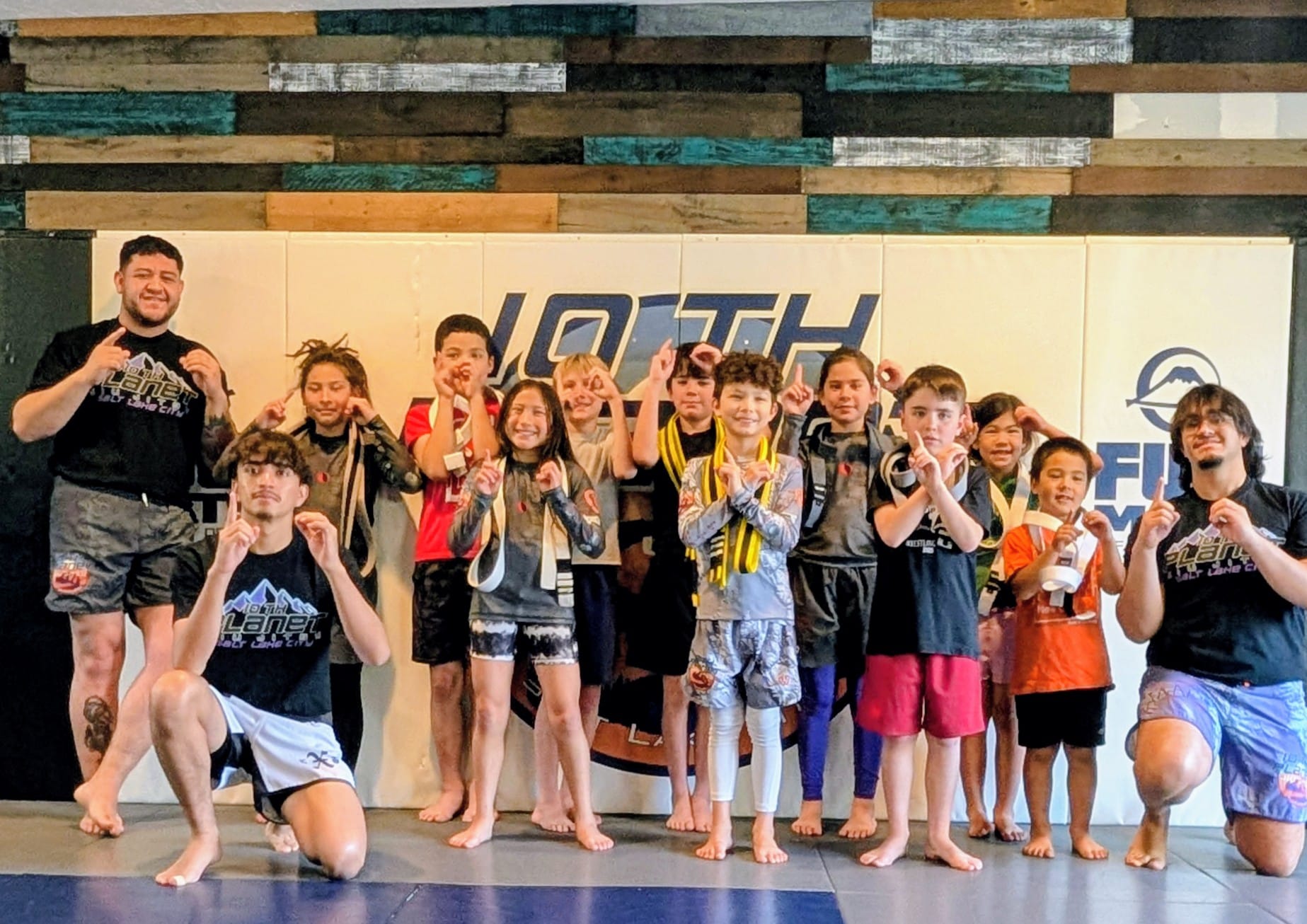 The 10P Kids! class group together on the mats